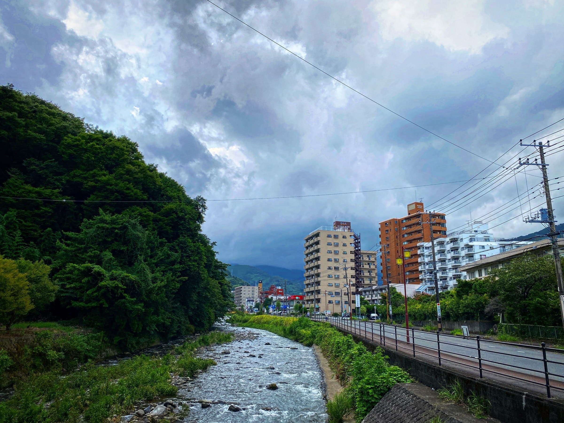 The Chitose River running through central Yugawara under a dramatic cloudy sky