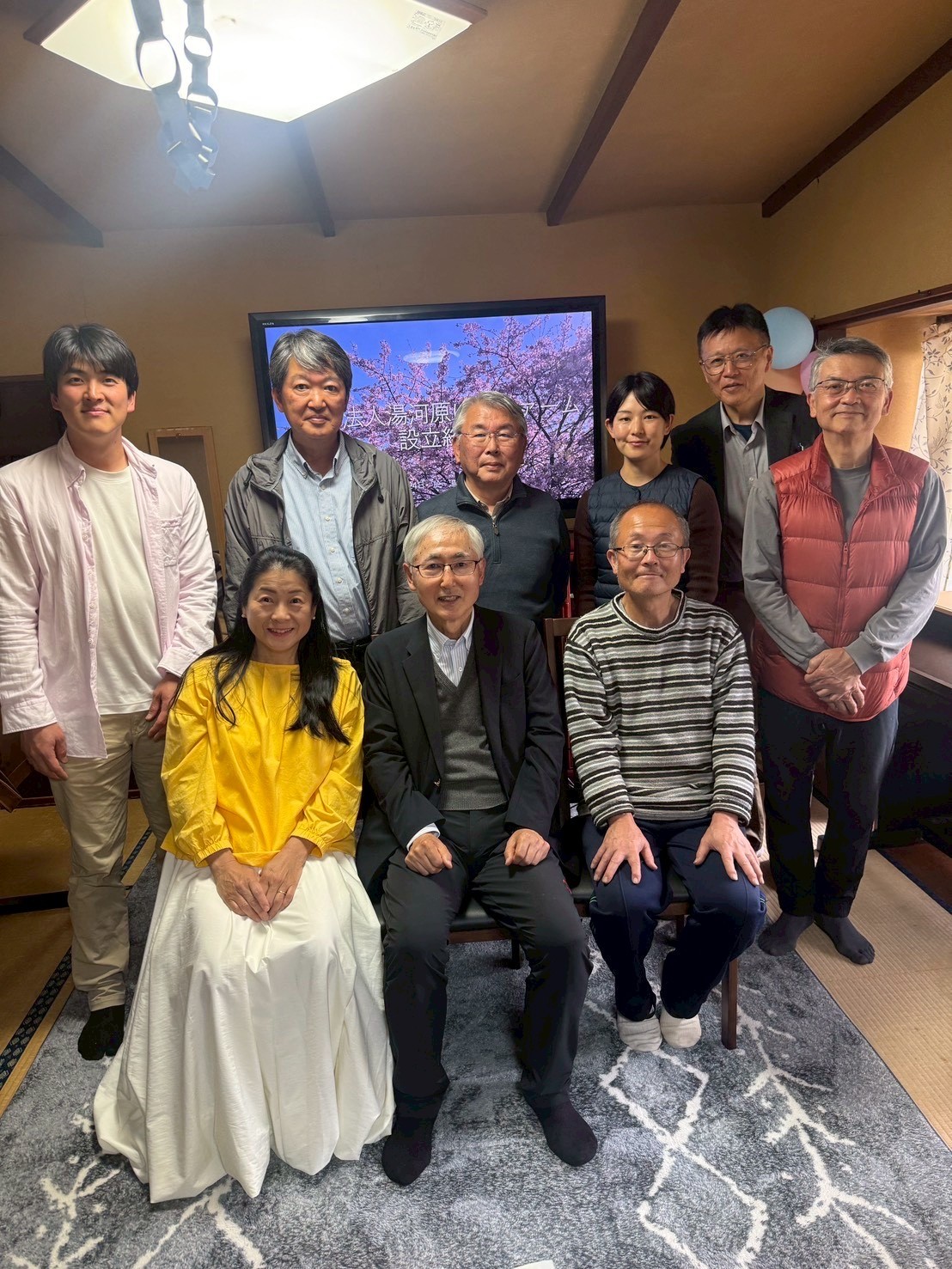室内で集合写真を撮る湯河原ゆめファームの9人のメンバー