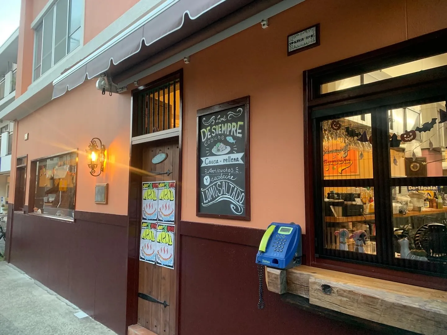 黒板メニューが並ぶオレンジ色の店先