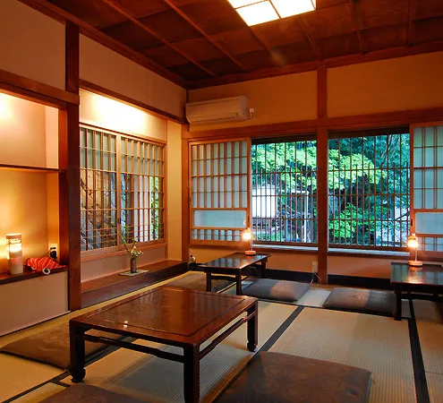 A tatami room with windows onto the trees