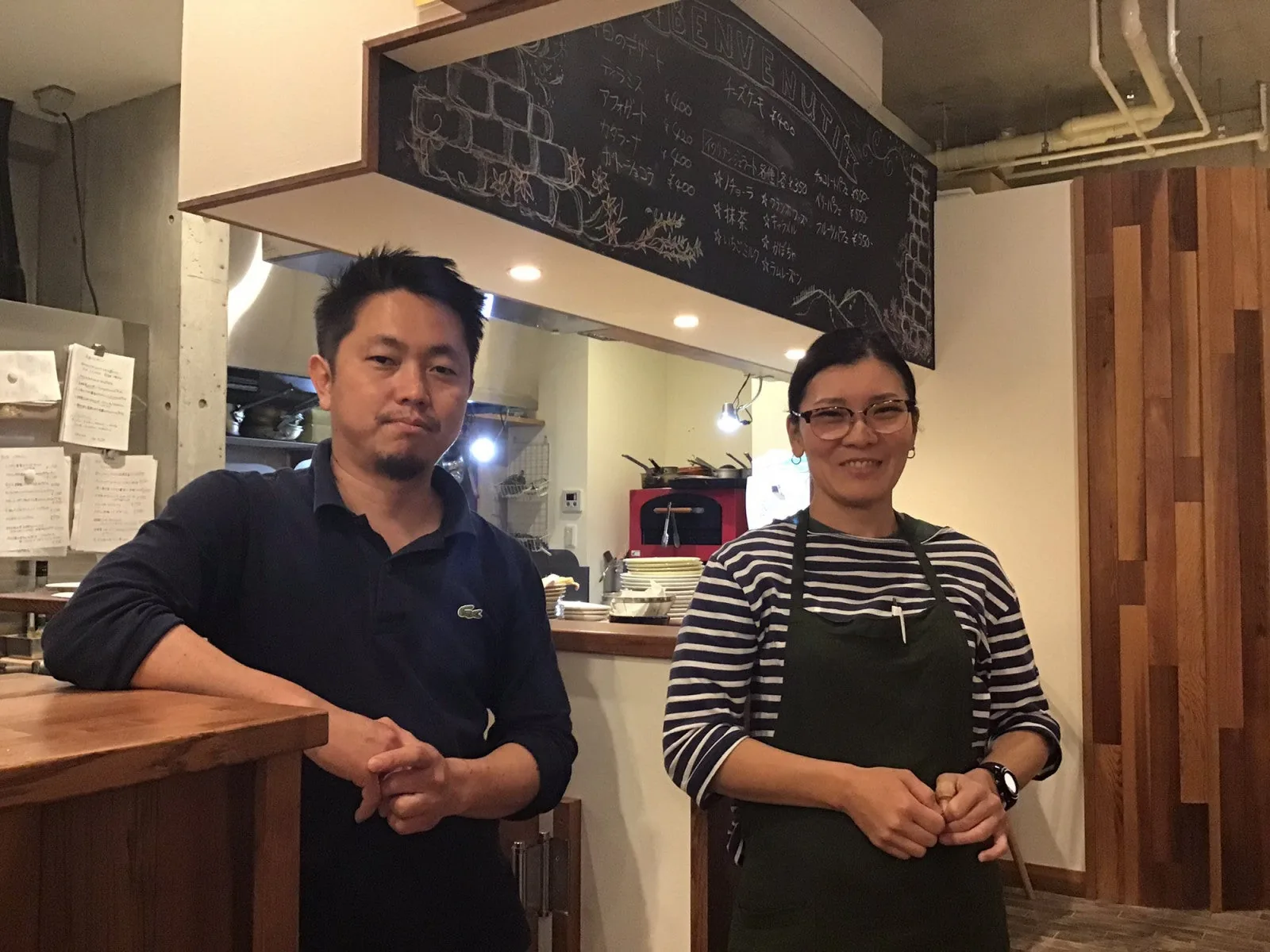 Two of Saluté's staff standing at the counter inside the restaurant